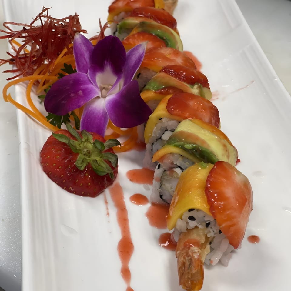 Saisaki Fort Wayne's sushi roll with shrimp tempura, avocado, mango, and strawberry, garnished with an orchid.